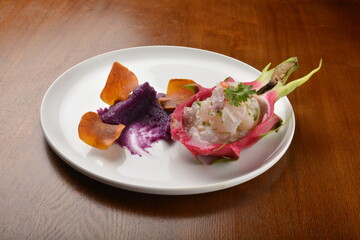 cold pink dragon fruit salad with root paste appetiser in plate on wood table fine dining western restaurant cafe halal menu