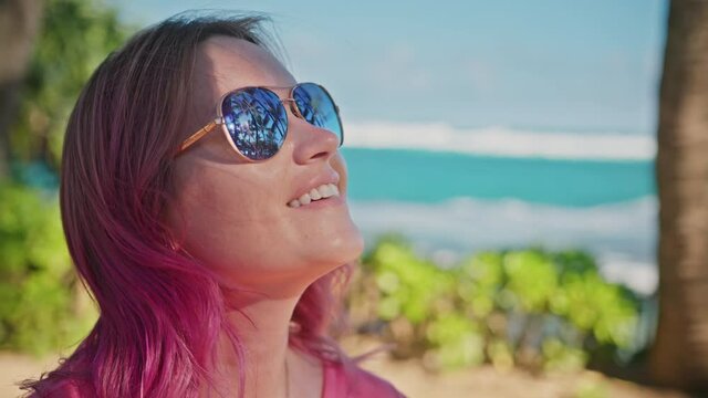Close up portrait of woman with pink hair, aviator sunglasses, beautiful smile