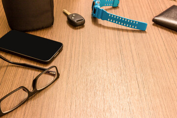 Glasses smart phone Watch key car wallet on the wood table in hotel holiday concept
