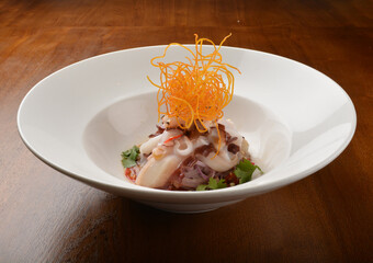 cold dish octopus sashimi salad with green vegetables and carrot appetiser on wood table fine dining western menu