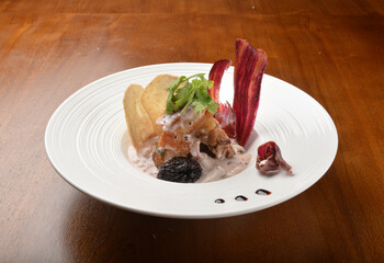 crispy pork belly with veggies and chef sauce appetiser on wood table fine dining western menu