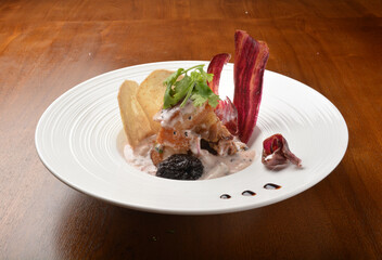 crispy pork belly with veggies and chef sauce appetiser on wood table fine dining western menu