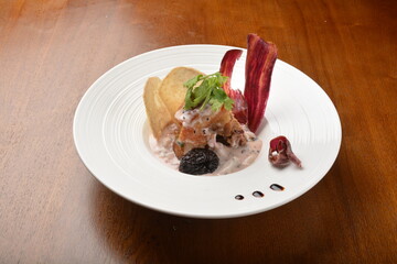 crispy pork belly with veggies and chef sauce appetiser on wood table fine dining western menu