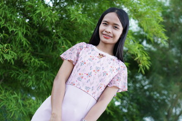 Naklejka premium Asian woman is walking happily in the middle of the meadow.