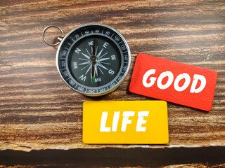 Business concept. Text GOOD LIFE on coloful board with compass on wooden table background.