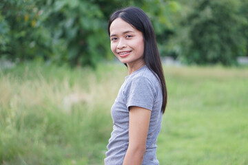 Fototapeta premium Asian woman is walking happily in the middle of the meadow.