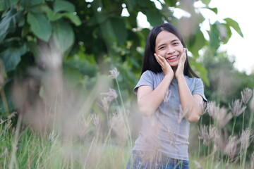 Asian woman  is walking happily in the middle of the meadow.