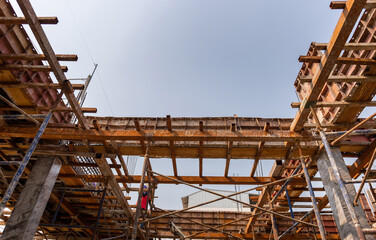 Beam formwork fabricated by construction worker, pillar and beam being constructed at the construction site