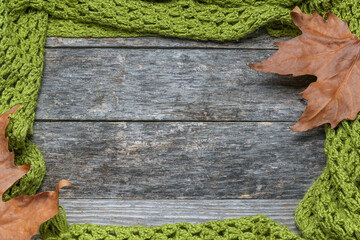 Knitted shawl with leaves on an old wooden table