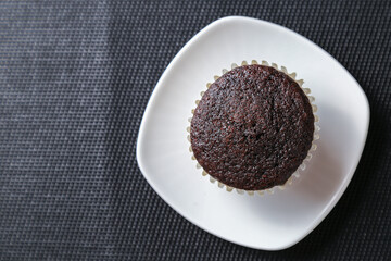 Delicious and fresh chocolate muffins on a gray ceramic table.