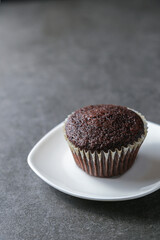 Delicious and fresh chocolate muffins on a gray ceramic table.