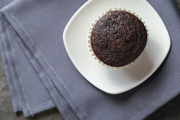 Delicious and fresh chocolate muffins on a gray ceramic table.