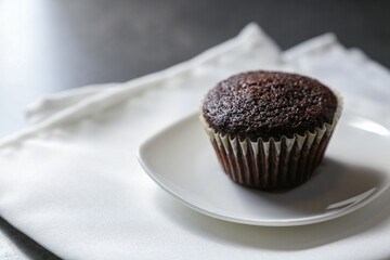 Delicious and fresh chocolate muffins on a gray ceramic table.