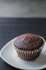 Delicious and fresh chocolate muffins on a gray ceramic table.