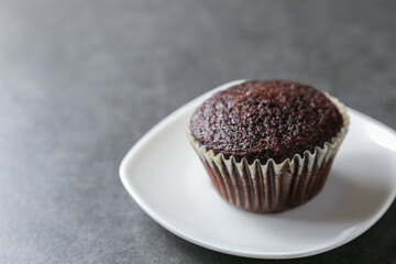 Delicious and fresh chocolate muffins on a gray ceramic table.