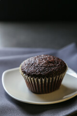 Delicious and fresh chocolate muffins on a gray ceramic table.