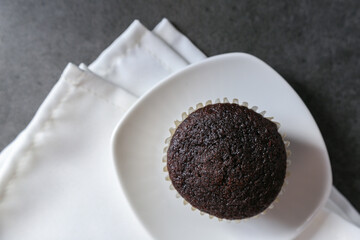 Delicious and fresh chocolate muffins on a gray ceramic table.