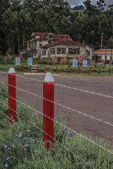 vertical shot green landscape with wooden fences of the gardens and view of the main house Sanatorio Durán on a beautiful and cold afternoon - Cartago - Costa Rica - Central America