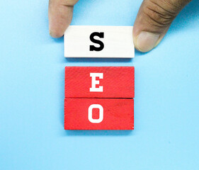 hand holding colored blocks with SEO letters