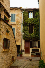 Fototapeta na wymiar Narrow street in the historical part of town in France, Antibes. Popular travel destination for the sidewalk in town