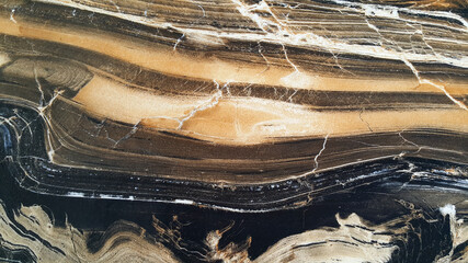 Black and brown background with the texture of natural marble with white veins, exotic limestone...