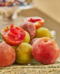 Red and yellow fresh plums on plate ready to eat