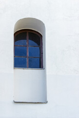 Antique window in a white wall