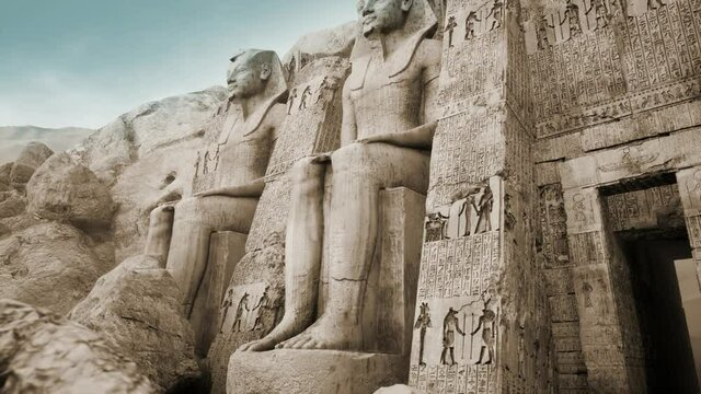 Egyptian temple at karnak with ancient pharaoh statues carved in the mountain