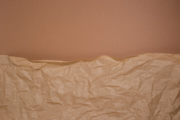 Crumpled craft paper on a brown cardboard background