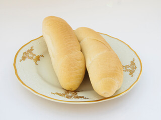 Fresh homemade rolls on porcelain plate on white background, selective focus