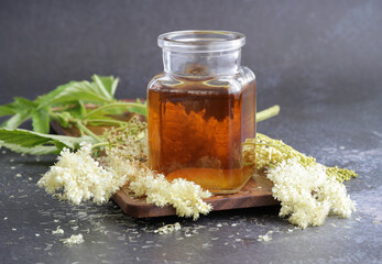 Medicinal tincture of meadowsweet in a glass jar.