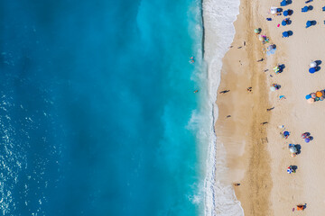 Aerial drone bird's eye view photo of most popular beach of Milos with turquoise clear waters and sun beds, island of Lefkada, Ionian, Greece
