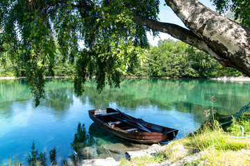 Boat under a tree in a green river.
