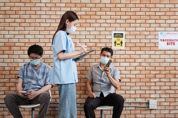 Nurse checks vaccinated queue of people, protect coronavirus (COVID-19) for health care campaign....
