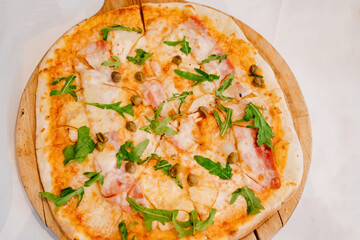 pizza with capers, arugula and bacon. traditional Italian cuisine. 