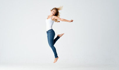 pretty blonde in jeans stands barefoot on the floor isolated background model