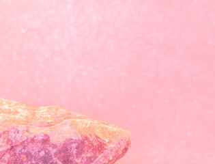 The Top of a Rock for a Product Display, Showing a Rough Textured Podium with a Yellow Pink and White Shelf, on a Bokeh Bubbles Blurred Background.