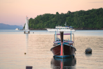 Fototapeta na wymiar Longtail boat mooring in the tropical sea at sunset background. Luxury Sailing theme.