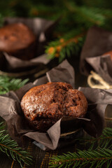 Delicious chocolate muffins on dark wooden background among fir branches, Merry Christmas and Happy New Year