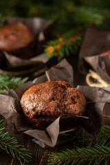Delicious chocolate muffins on dark wooden background among fir branches, Merry Christmas and Happy New Year
