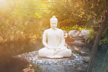 buddha consciousness light. Buddha statue meditating in the nature near the water