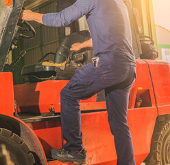 Man climbing on a forklift.