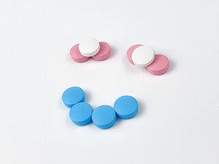 Smiling face sign made of vitamins. Vitamins and supplements on white background. Concept for a healthy dietary supplementation. Closeup.