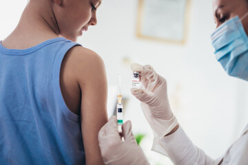 Coronavirus vaccination. Covid-19 vaccine. Doctor vaccinating child. Little boy getting flu shot.