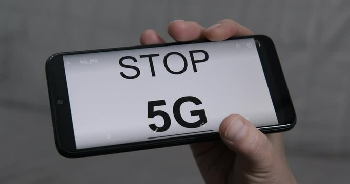 Stop 5G. Man shows the inscription on the smartphone stop 5G.