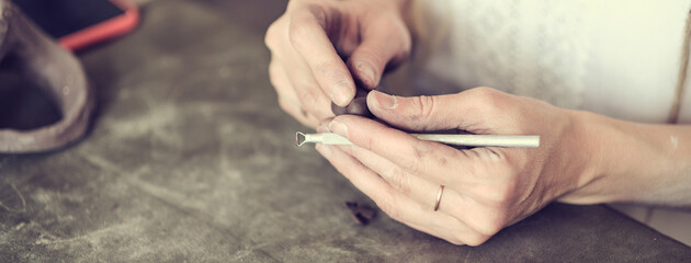 Obraz premium artisan pottery tutor. women's hands shake a piece of gray clay. Pottery made of clay with their own hands. Holding a grey ball