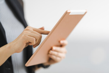 Close-up of a businesswoman in business uniform using a digital tablet outside the workplace. Business stock photo