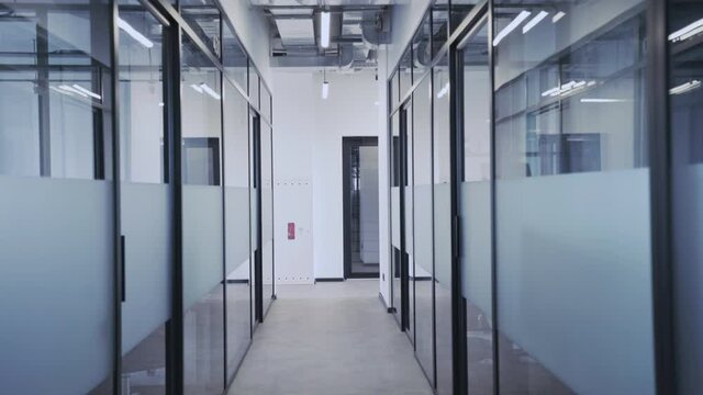 Empty office corridor with glass walls and many doors, comfortable workplace