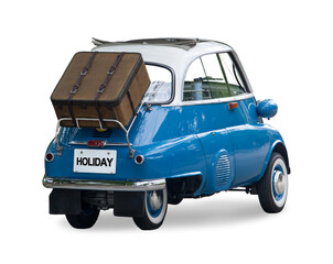 A small retro car with a suitcase attached to the back is ready for a trip, isolated on a white background. - Powered by Adobe