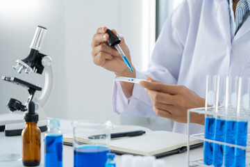 Scientist wear lab coat and protective wear are working with research or doing investigations with test tubes in experiment, Laboratory and development concept